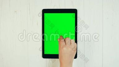 平板绿色屏幕上的手指滑动。 放大手势。