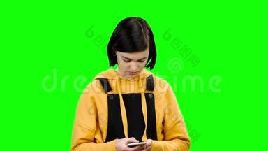 女孩正在她的智能<strong>手机</strong>上<strong>输入</strong>一条信息。 绿色屏幕