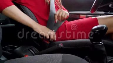 在驾驶前，身着红色礼服的女士在车内系紧安全带