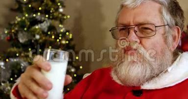 圣诞老人在椅子上放松，吃甜食和喝牛奶