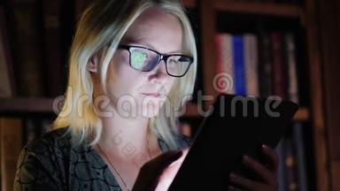 一个女人<strong>深夜</strong>在图书馆里用平板电脑<strong>工作</strong>。 <strong>工作</strong>到很晚