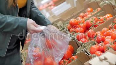 漂亮的年轻漂亮的红发女人在市场上，在超市里买食物、水果、西红柿。 女孩选择