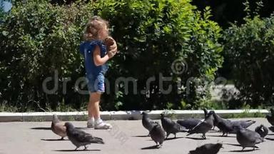 小女孩正在公园里喂鸽子