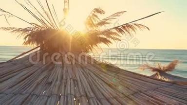 海滩上空的热带日出。 热带海滩和阳伞上的日出