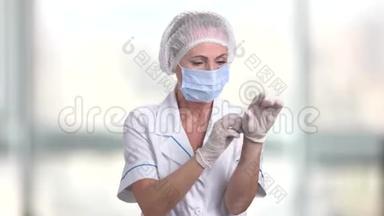 自信的女医生戴上手套。