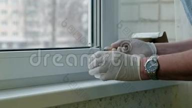 一个戴着橡胶手套的人用刮刀将窗台复原，用浆糊涂在破损的地方