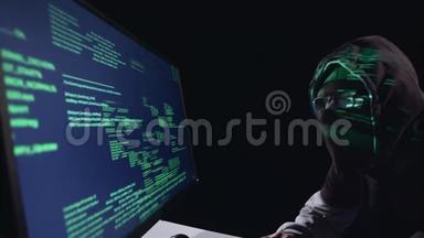 间谍黑客电脑坐在黑暗的房间里。 黑色背景