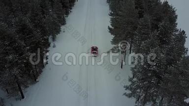 空中全景，唯一的红色汽车在道路上美丽的冬季景观拉普兰在降雪。