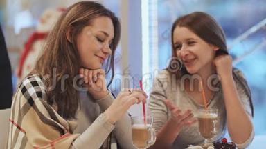 两个女<strong>学生</strong>的女朋友喝鸡尾酒，在咖啡馆里<strong>聊天</strong>。 秋天，冬天。