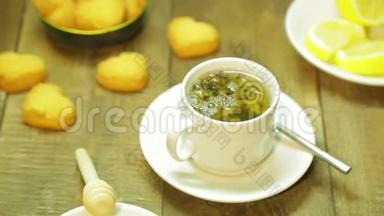 在木桌上的白色杯子里新鲜<strong>冲泡</strong>的绿茶