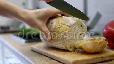 一个女人用<strong>面包刀</strong>切一条<strong>面包</strong>。 慢动作
