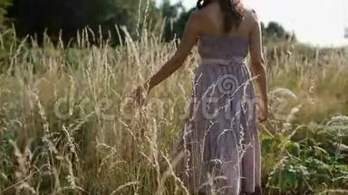 女人触摸田野里的枯草