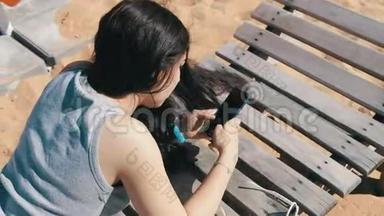躺在沙滩躺椅上的女孩移动智能手机触屏