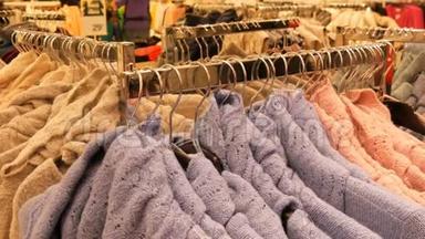 服装店购物中心衣架上挂着大量不同颜色的新款保暖时尚毛衣