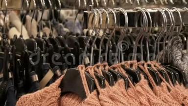 服装店购物中心衣架上挂着大量不同颜色的新款保暖时尚毛衣