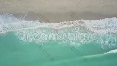 在迈阿密，阳光明媚的艾尔斯海滩，靠近白色沙滩海岸的图尔奎斯波浪状海水上空飞行