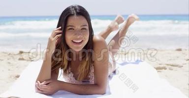嘲笑快乐的年轻女人在海滩上<strong>晒太阳</strong>
