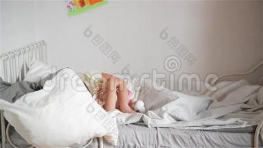 男孩扔一个枕头给睡觉的女孩，开心的笑着哥哥和姐姐打一个枕头