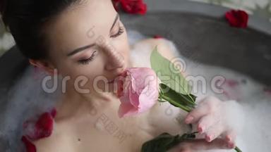 小女孩躺在一个大石头浴缸里，手里拿着一朵玫瑰花