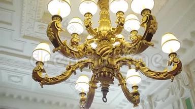 吊灯悬挂在宫殿的天花板下。 豪华天花板吊灯