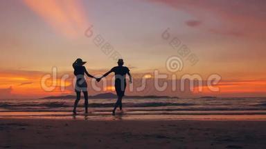 在海边的夕阳下，一对幸福的情侣在海滩上相遇并玩耍