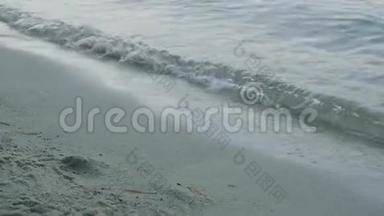 沙滩上的海浪。泡沫海浪在海滩冲上岸的特写镜头