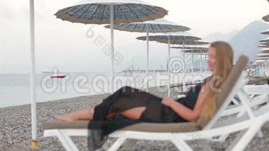 海滩上的女人躺在沙滩上享受大海