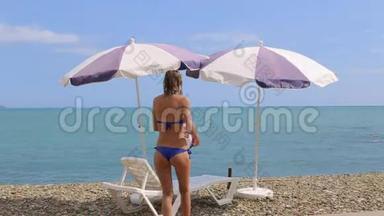 女人在加勒比海海滩上放松，有太阳伞和床。