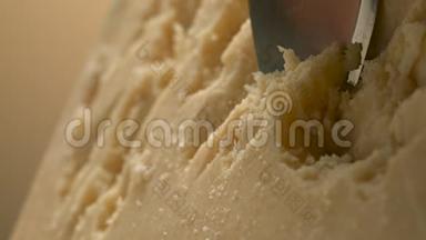 一把锋利的刀把坚硬的奶酪切成小块。 帕米森。 很漂亮的摄影棚。 相机幻影Flex。