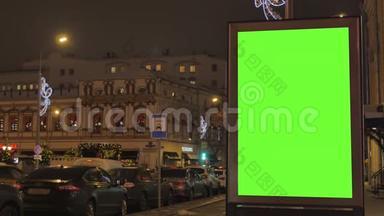 一个大广告牌，街道上有一个绿色的屏幕，为节日装饰。