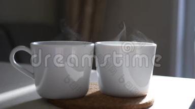 两个白色杯子，热咖啡和蒸汽在<strong>阳光下</strong>。 慢动作。 1920x1080。 高清高清