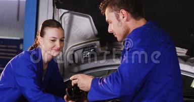 男机修工检查汽车零件，女机修工维修汽车