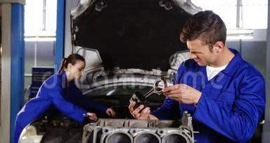 男机修工检查汽车零件，女机修工维修汽车