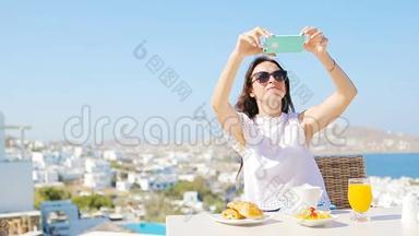 女士用手机拍照早餐。 女孩在豪华旅行度假时拍照留念