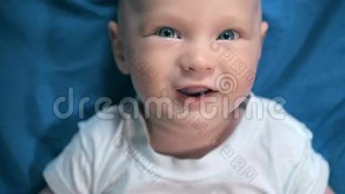 可爱的小男孩在蓝色阳光的卧室。 新生儿在床上放松。 幼儿保育院.. 纺织和床上用品