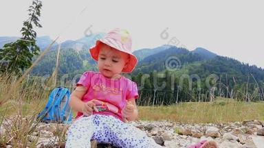 一个小孩子坐在炎热的夏天的山上。 全高清。 1920x1080