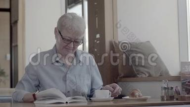 一个养老金<strong>领取</strong>者在咖啡馆里，读一本有趣的书