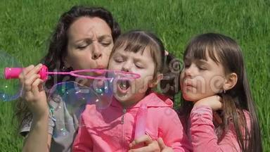 妈妈和女儿吹泡泡。 公园里的家人。 和妈妈在一起的孩子在玩泡泡。
