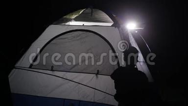 两名成年男子和儿童从越野车上<strong>搭帐篷</strong>的夜间镜头。
