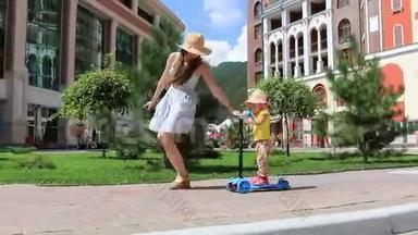 妈妈教孩子在阳光明媚的夏天在公园里骑滑板车。 全高清。 1920x1080