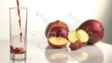 在苹果模糊的背景下，空玻璃的特写镜头充满了红色的果汁。