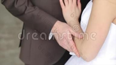 新婚夫妇牵着手，幸福的新郎和新娘。 新郎新娘手拿戒指，关紧