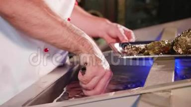 厨师从海鲜餐厅水族馆取出贝壳，特写。