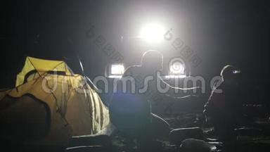 两名成年男子和儿童从越野车上搭帐篷的夜间镜头。