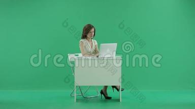 女人坐在桌子旁，双脚站在桌子上打电话