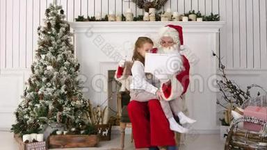 圣诞老人和可爱的小女孩在平板电脑上做圣诞自拍