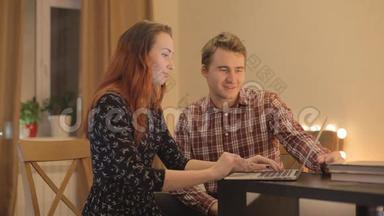 年轻夫妇在讨论<strong>网络购物</strong>，笔记本电脑