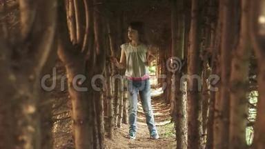 小女孩走过树洞。 神秘而神奇的森林里的孩子。 慢动作
