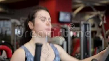 两个女人在健身房里使用运动机。 一群女人。 女孩在窗户上做运动。 体育运动。 健身房