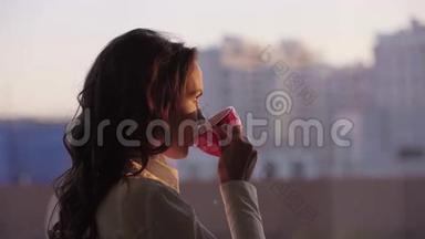 年轻漂亮的女商人欣赏城市风景，在日落时分<strong>喝茶</strong>，在现代办公室<strong>喝茶</strong>